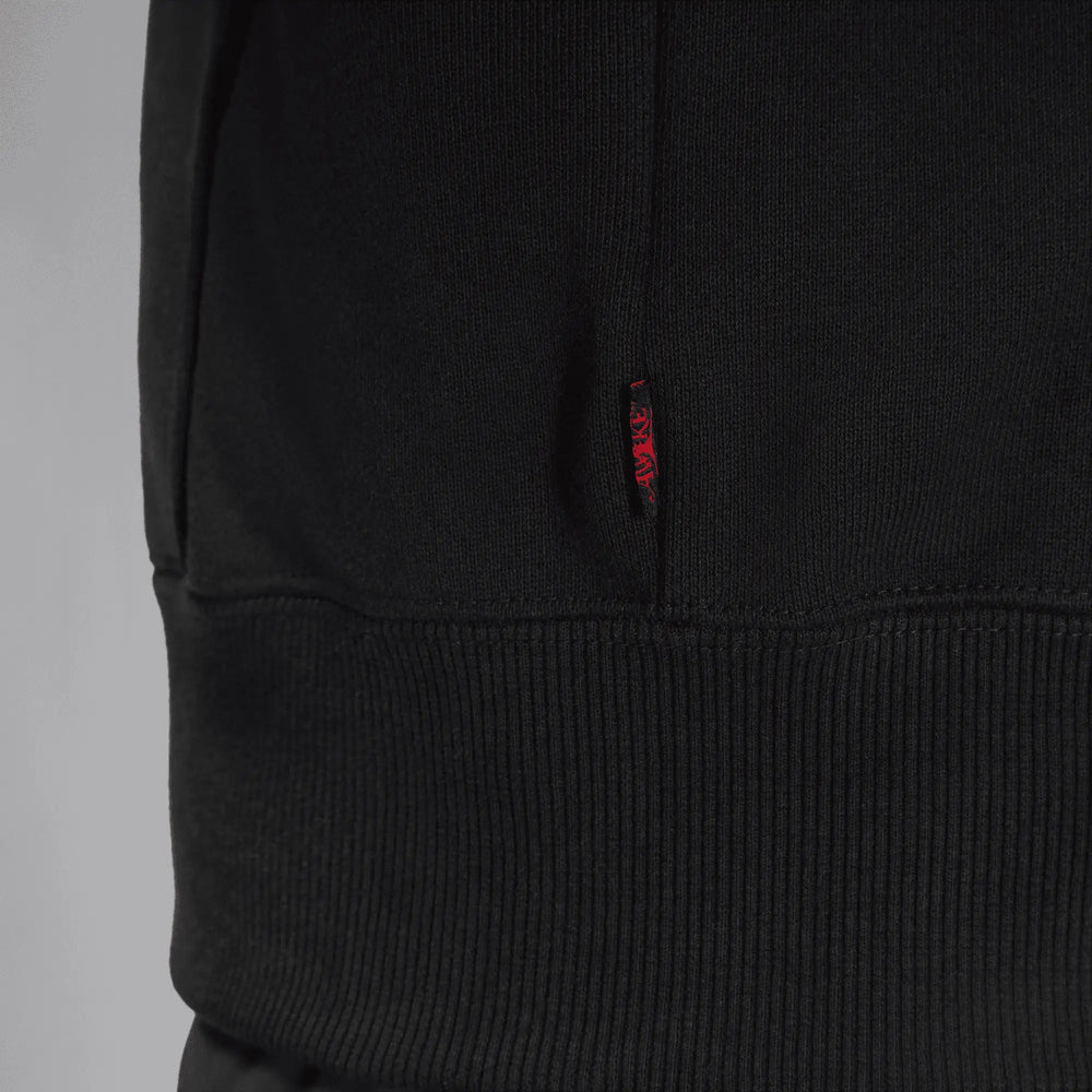 Close-up detail of the red Awake woven label on the black Jordan x Awake NY fleece hoodie.